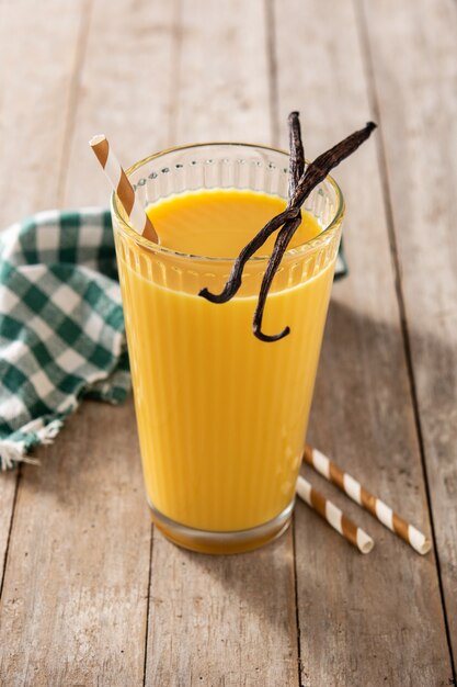 Köstlicher Vanillemilchshake im Glas auf Holztisch