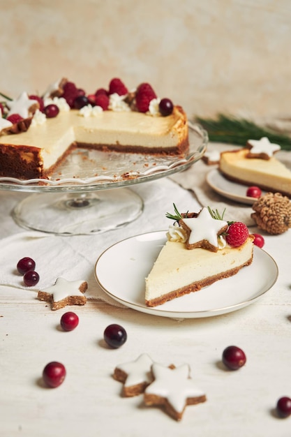 Köstlicher Weihnachtskäsekuchen mit Preiselbeeren und Kekssternen auf einem weißen Tisch