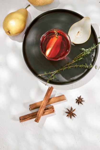 Köstlicher würziger heißer Glühwein mit Zimt-Sternanis und geschnittener Birne, serviert in einer Karaffe und einem Glas für einen kalten Winterabend oder ein festliches Weihnachtsgetränk