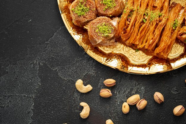 Foto köstliches baklava-dessert in orientalischer umgebung auf schwarzem hintergrund