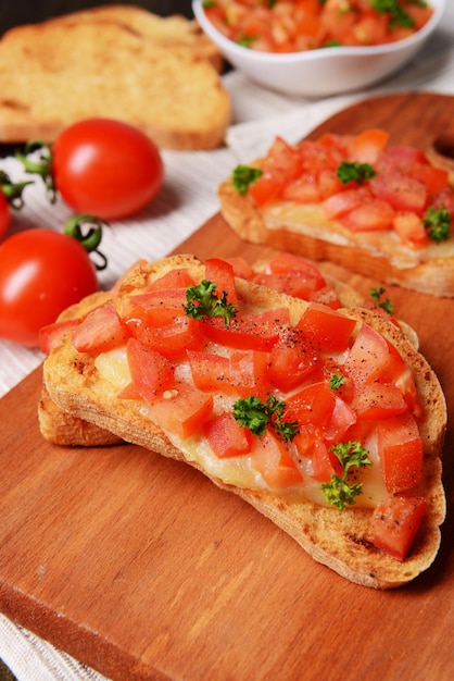 Köstliches Bruschetta mit Tomaten auf Schneidebrettnahaufnahme