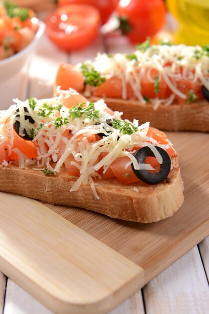 Köstliches Bruschetta mit Tomaten auf Schneidebrettnahaufnahme