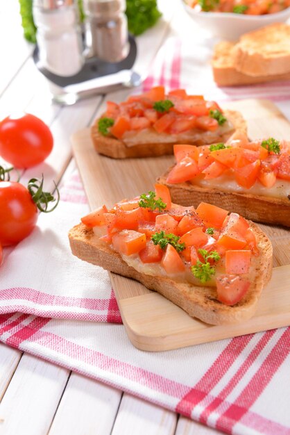 Köstliches Bruschetta mit Tomaten auf Schneidebrettnahaufnahme