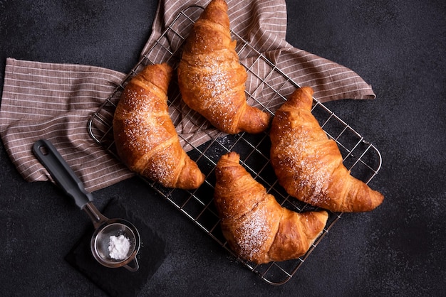 Köstliches frisch gebackenes Croissant auf dunklem Hintergrund