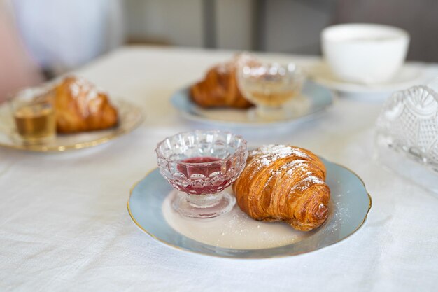 Köstliches frisches Croissant auf einem Teller am Tisch