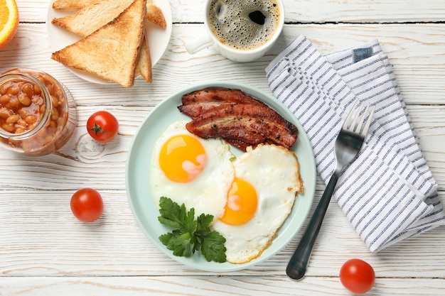 Köstliches Frühstück oder Mittagessen mit Spiegeleiern auf weißer Holzoberfläche, Draufsicht