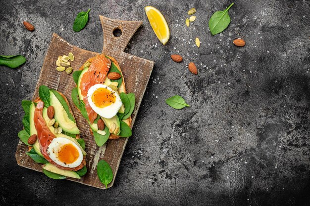 Köstliches Frühstück oder Snack-Vollkornbrot mit Avocadopaste und Lachs-Keto-Paläo-Diät-Banner-Menü-Rezeptplatz für Text-Draufsicht