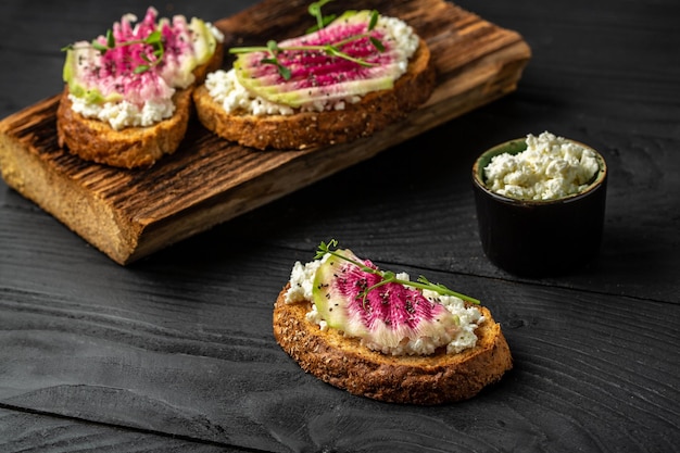 Köstliches Frühstück oder vegetarische Snack-Toasts aus geschnittenem Wassermelonen-Rettich und Ziegenkäse-Banner-Catering-Menü-Rezeptplatz für Text-Draufsicht