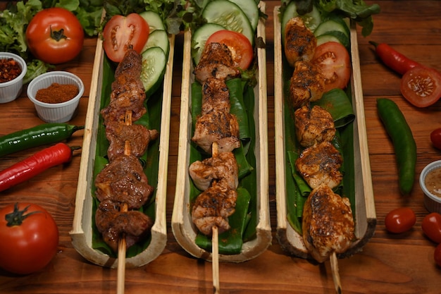 Köstliches gegrilltes Fleisch mit Sichuan-Pfeffer, chinesischen Gewürzen und Gemüse auf einem Holztisch