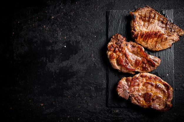 Köstliches gegrilltes Schweinesteak auf einem Steinbrett