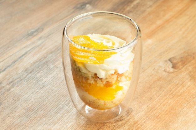 Köstliches kleines Dessert in Gläsern. Dessert mit Schlagsahne, Obst, Mango. Süßigkeiten nach dem Mittagessen. Lebensmittelfoto für Rezept oder Menü