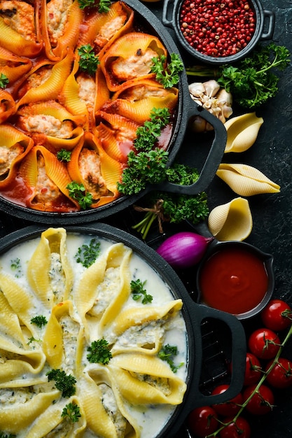 Köstliches Makkaroni-Rezept mit Fleisch, Tomaten, Sahnesauce, Petersilie und Parmesan Traditionelles italienisches Mittagessen auf Steinhintergrund