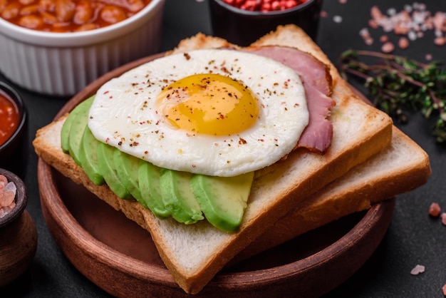 Köstliches, nahrhaftes englisches Frühstück mit Spiegeleiern, Tomaten und Avocado