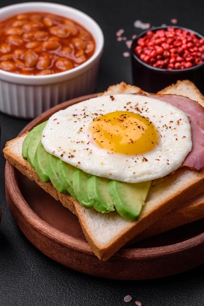 Köstliches, nahrhaftes englisches Frühstück mit Spiegeleiern, Tomaten und Avocado