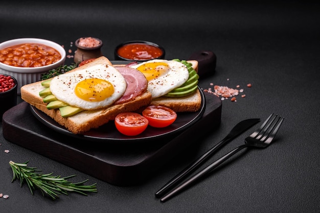 Köstliches, nahrhaftes englisches Frühstück mit Spiegeleiern, Tomaten und Avocado