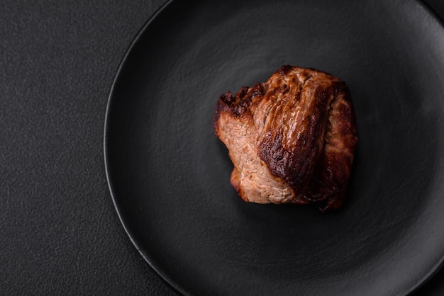 Köstliches Rindersteak mit Salzgewürzen und Kräutern auf einem Keramikteller