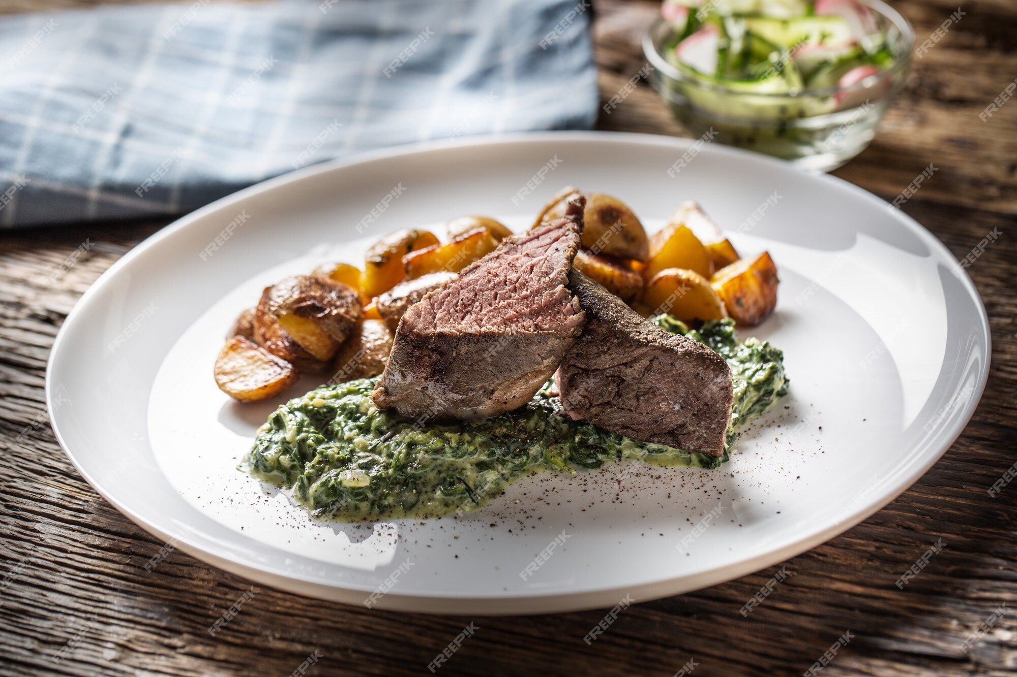 Gutter arm høj Köstliches sous-vide-steak vom grill, serviert auf einem weißen teller mit  knusprigen bratkartoffeln, spinat-dip und frischem blattsalat. |  Premium-Foto