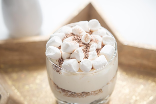 Köstliches süßes Dessert mit Sahne in einem Glas auf hellem Hintergrund ein schönes Frühstück