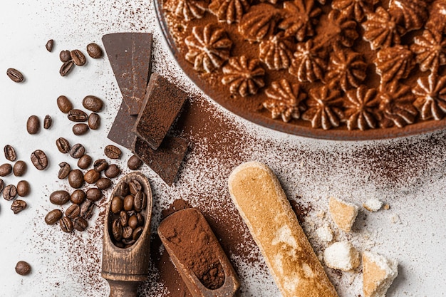 Köstliches traditionelles hausgemachtes Dessert Tiramisu aus den klassischen italienischen Rezeptkeksen Savayardi Kaffeeschokolade und Kakao auf weißem Marmorhintergrund Dessert Tiramisu