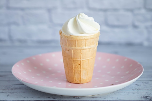 Köstliches weißes cremiges Eis in einem knusprigen Waffelbecher. Süßes kaltes Dessert.