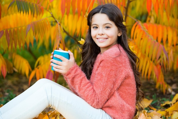 Koffeinsüchtig Kleines Kind hält Tasse mit Koffein-Energy-Drink Kleines Mädchen lädt sich mit heißem Koffein-Getränk auf knusprigem Herbst auf