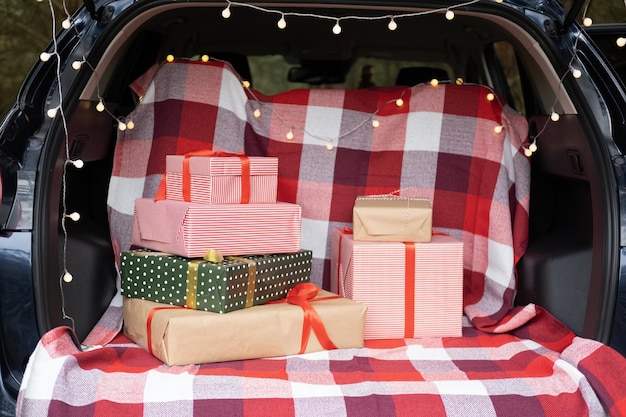 Kofferraum voller Geschenkboxen, Geschenke und Girlanden für die Weihnachtsferien