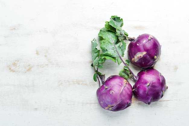 Kohlrabi-Kohl mit grünen Blättern auf hölzernem Hintergrund Draufsicht Freier Platz für Ihren Text