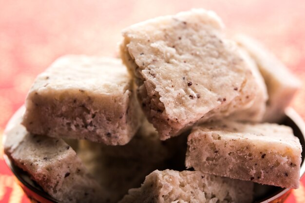 Kokos-Burfi oder Nariyal Barfi ist ein süßer Kuchen, der in einem selektiven Fokus auf einem Teller serviert wird