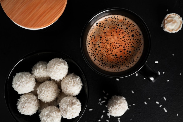 Kokosbonbons mit Nüssen auf dunklem Hintergrund Raffaello auf schwarzem Hintergrund Hochwertiges Foto