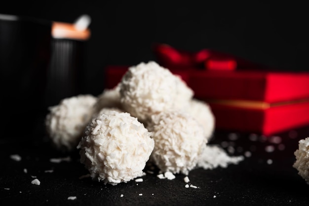 Kokosbonbons mit Nüssen auf dunklem Hintergrund Raffaello auf schwarzem Hintergrund Hochwertiges Foto