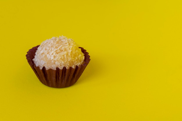 Kokosmarmelade und Kondensmilch. Brasilianische traditionelle Süßigkeit auf gelbem Hintergrund isoliert.