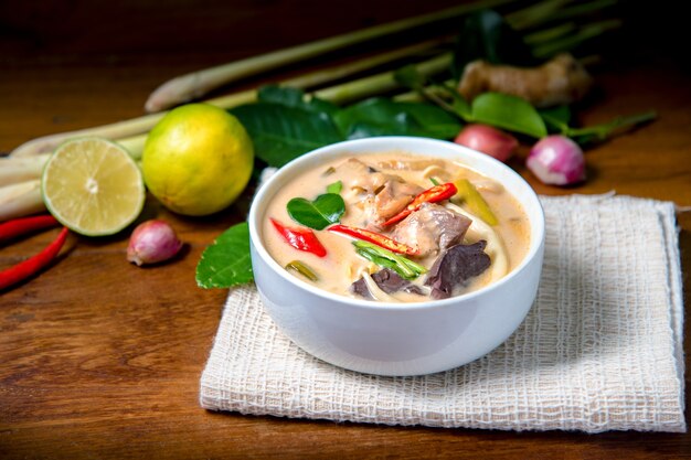 Kokosmilch mit Huhn auf Holzfußboden. Traditionelle thailändische Suppe