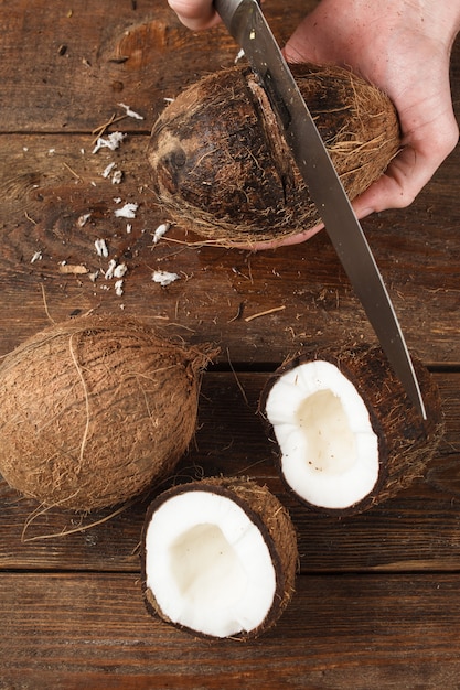 Kokosnüsse auf braunem Holz geschnitten