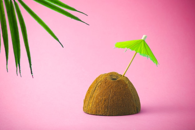 Kokosnuss auf einem rosa Strandhintergrund