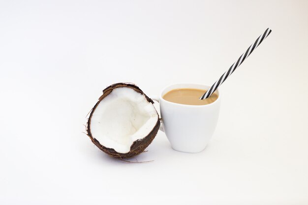 Kokosnuss und Kaffee mit Milch auf einem weißen Hintergrund