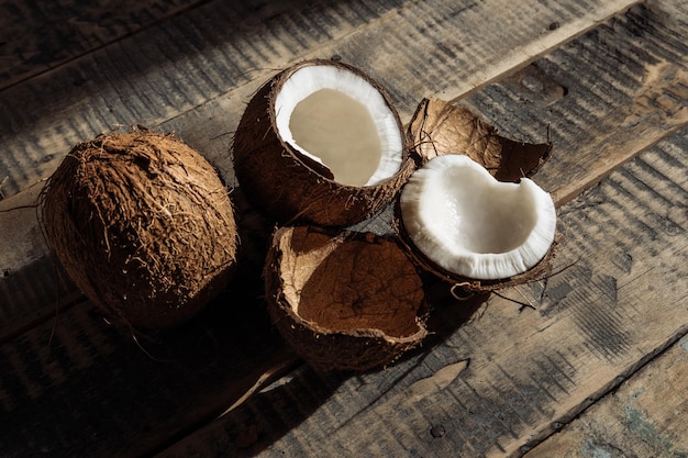 Kokosnuss und Milch gebrochene Kokosnuss Kokosnuss auf Holzbrettern Hintergrund