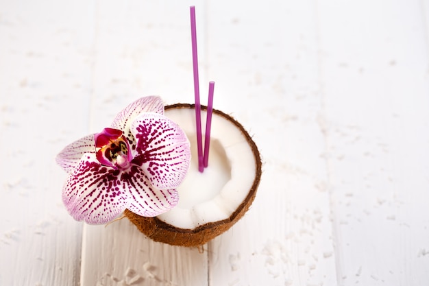 Kokosnuss verziert mit Orchidee auf Holztisch