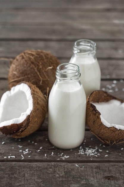 Kokosnusskefir in Flaschen auf Holztisch. Konzept für gesunde Ernährung. Fermentierte Getränke