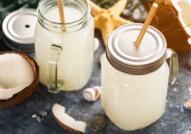 Kokosnusssaft oder Wasser oder Milch in Gläsern Gesundes tropisches Sommergetränk