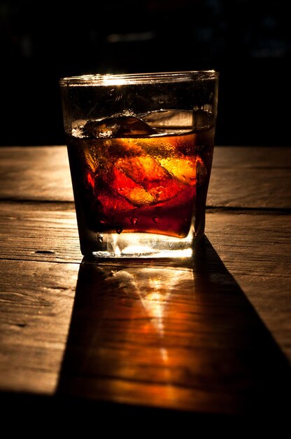 Kolabaum mit Whisky und Eis auf einem Holztischhintergrund