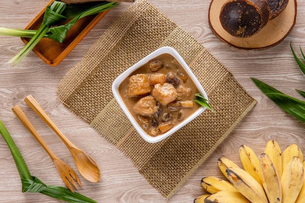 Kolak Pisang Ubi oder Bananen-Süßkartoffel-Kompott ist ein beliebtes Dessert in Indonesien während des Ramadhan Kolak Pisang Ubi aus Kokosmilch Palmzucker Bananen-Süßkartoffel und Pandanus-Blätter Leave