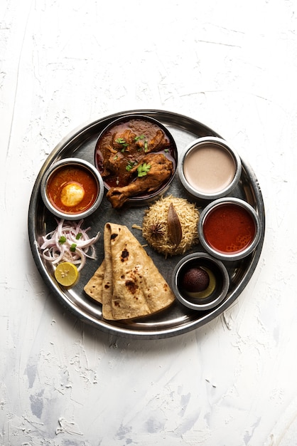 Kolhapuri Chicken Thali ist eine beliebte indische, asiatische Speisenplatte bestehend aus Geflügelfleisch, Eiercurry mit Chapati, Reis, Salat und süßem Gulab Jamun