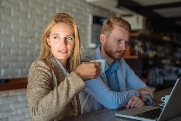 Kollegen arbeiten gemeinsam an einem Computer in einem Café