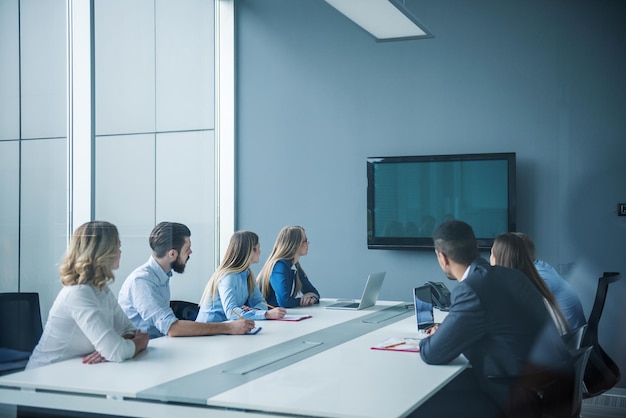 Kollegen arbeiten in einem Konferenzraum zusammen.