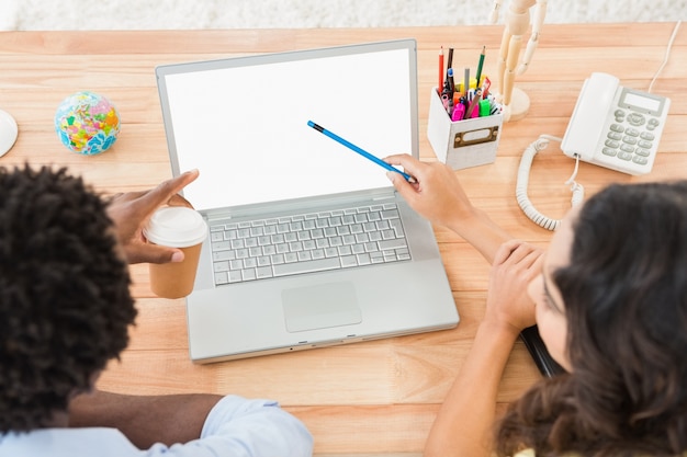 Kollegen brainstorming und Laptopbildschirm zeigend