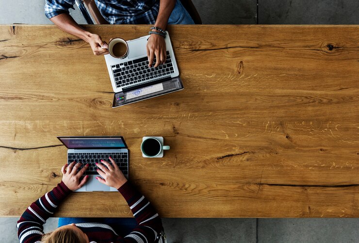 Foto kollegen, die an einem schreibtisch auf laptops zusammenarbeiten