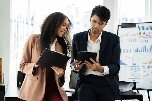 Kollegen, die ein digitales Tablet in Coworking-Mitarbeitern verwenden, die im Sitzungssaal zusammenarbeiten, um Geschäftsstrategien zu diskutieren und zu analysieren