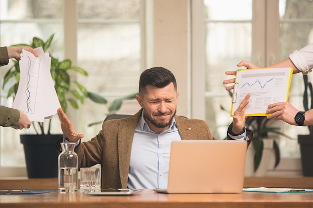 Kollegen, die in modernen Büros mit Geräten und Gadgets während eines kreativen Meetings zusammenarbeiten