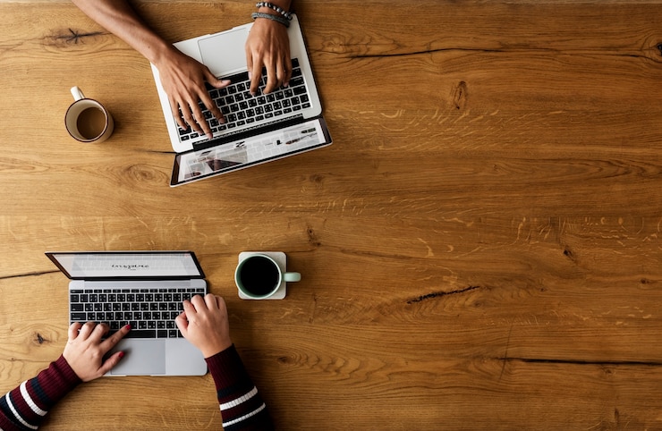 Foto kollegen, die zusammen arbeiten an laptop sitzen