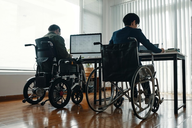 Kollegen mit Behinderungen, die an Computern arbeiten